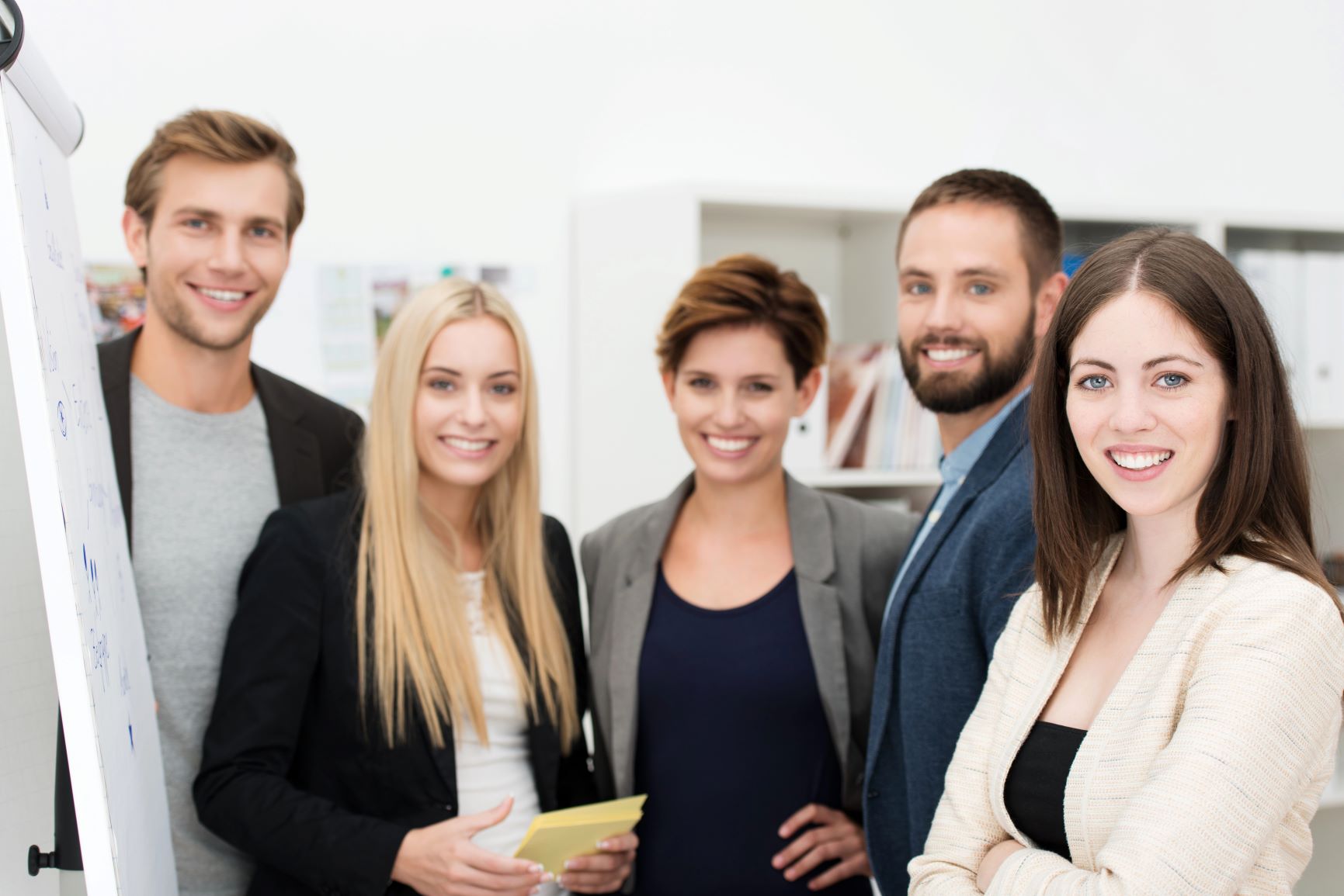 grupa usmiechniętych, młodych ludzi, ujęcie od pasa